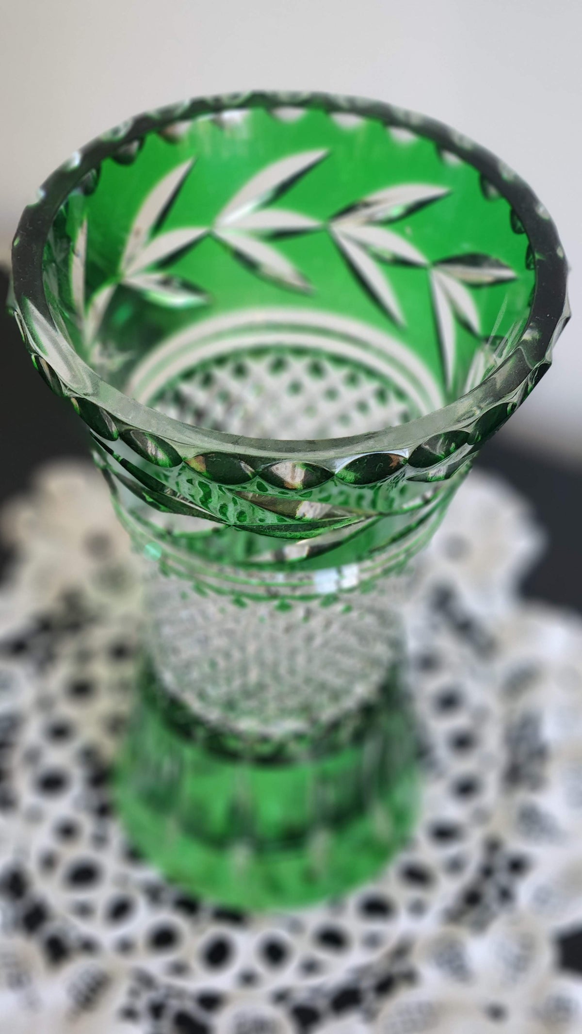 Emerald green cut-to-clear vase with flared rim, leaf cuts, and diamond-cut center