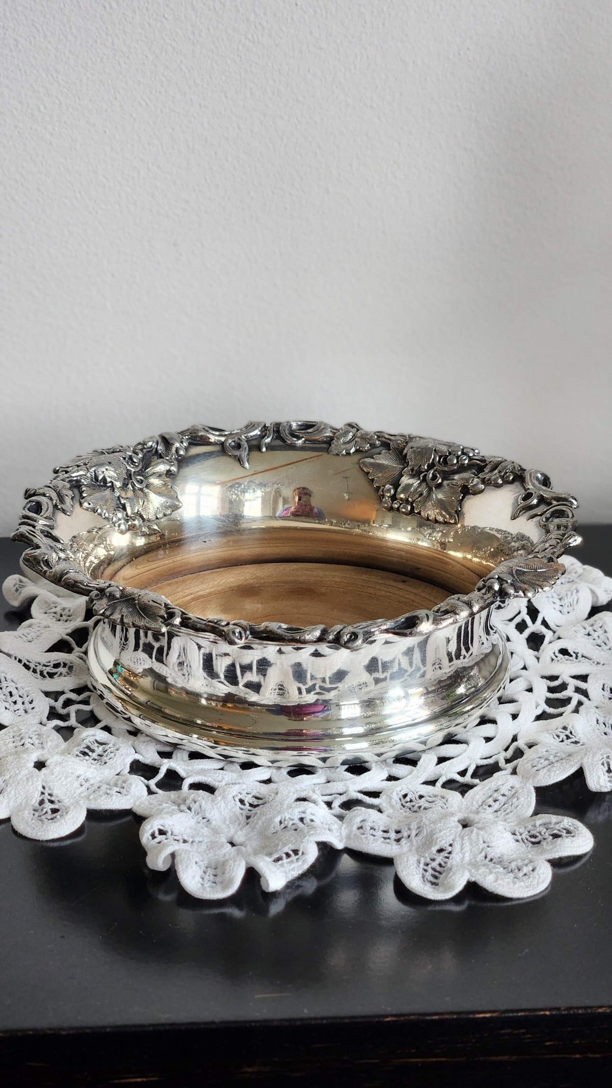 Close-up of grape and leaf details on silverplate wine coaster rim