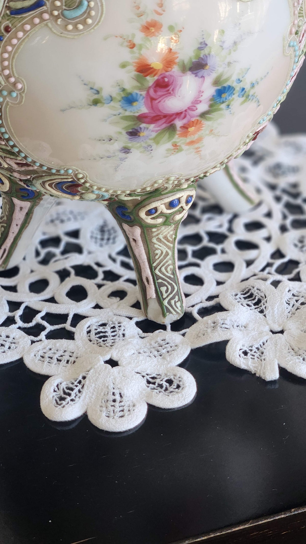 Close-up of decorated vase leg showing small chip or loss