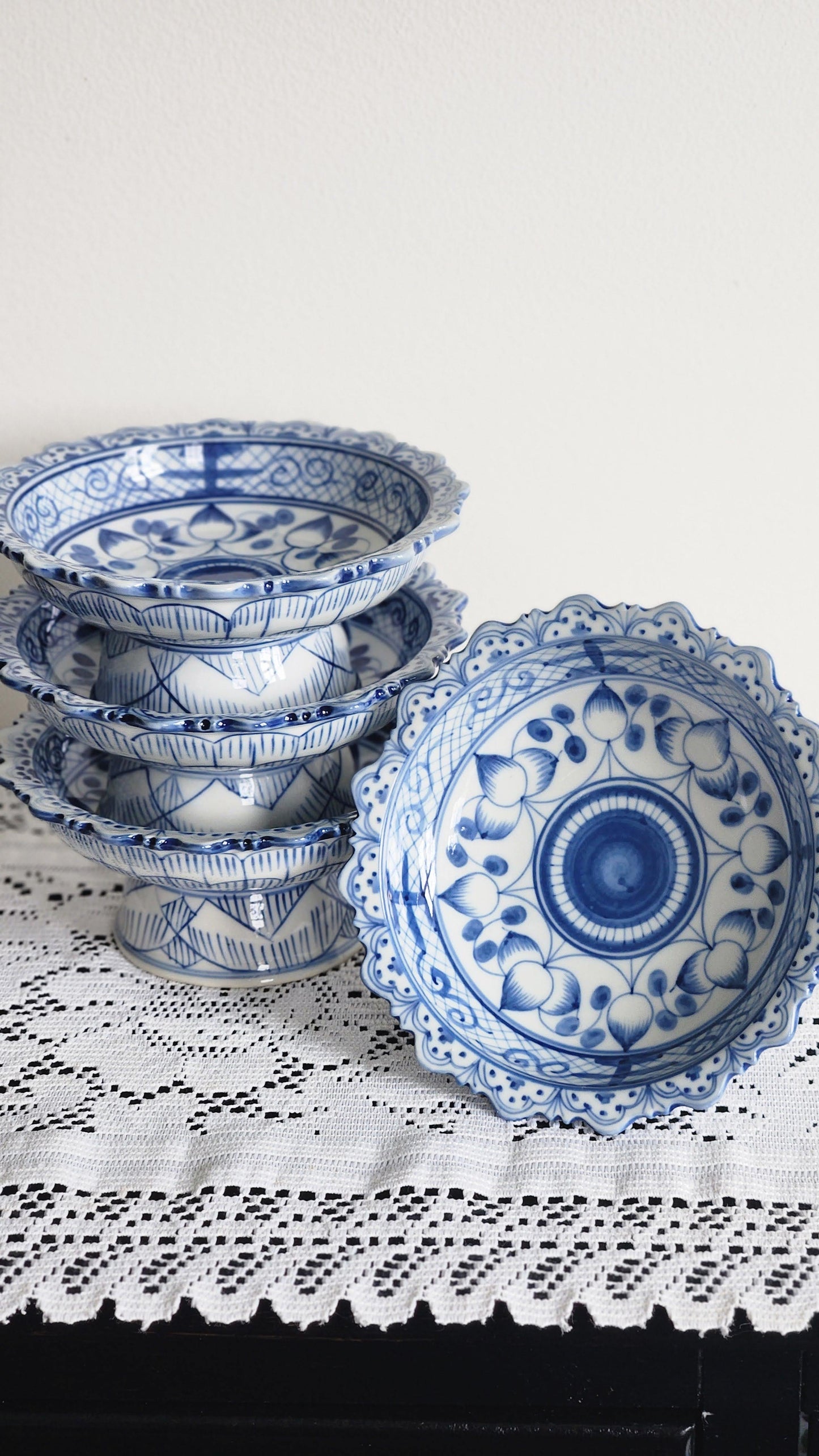 Set of 4 blue and white scalloped porcelain pedestal bowls, stacked side view