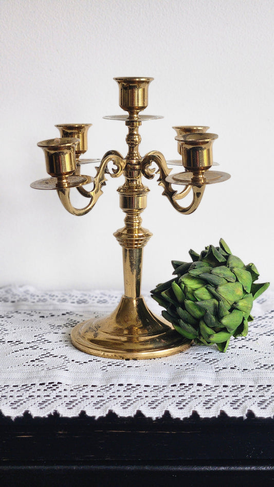 Vintage brass 5-arm candelabra with scrolled arms and baluster column on lace tablecloth
