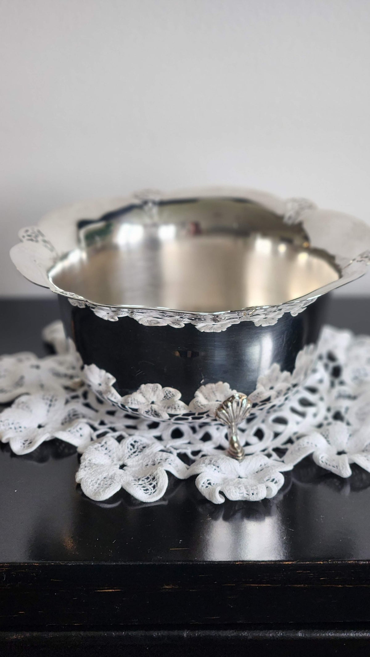 Side view of vintage silverplate footed bowl with scalloped rim and decorative foot