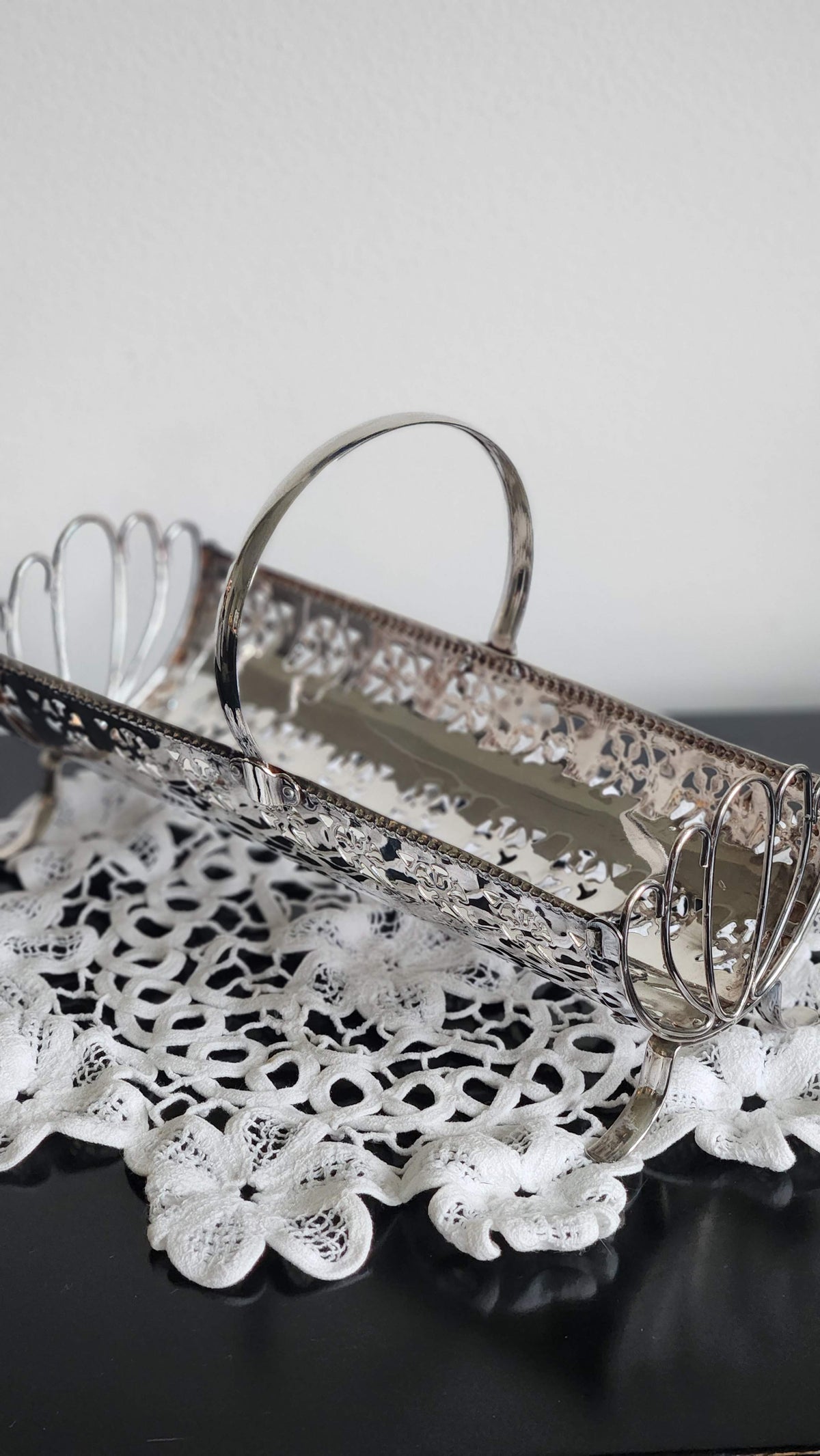 Angled view of silverplate cracker basket showing beaded rim and narrow trough-shaped interior