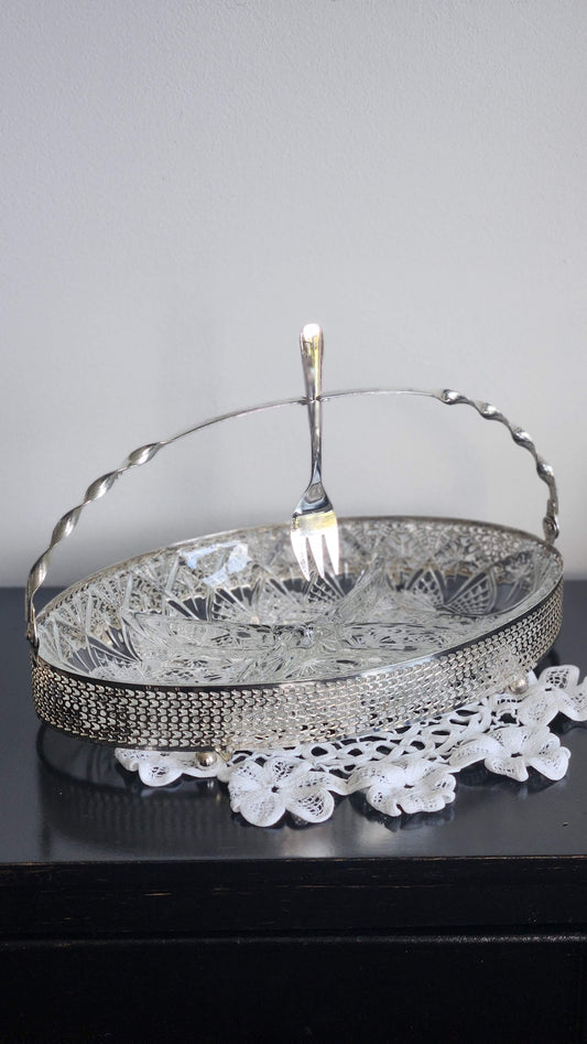 Oval silverplate relish server with pressed-glass insert, pierced gallery, swing handle, and serving fork