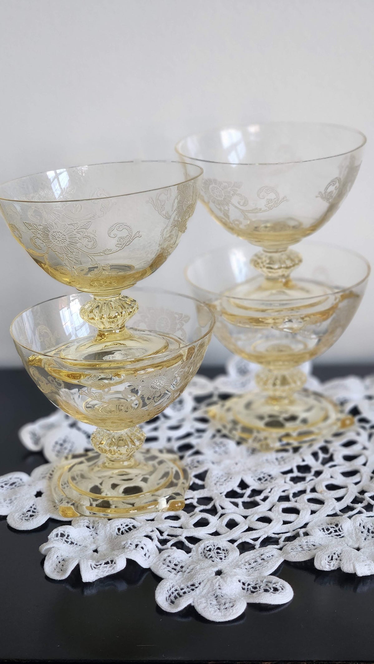Close view of floral and scrolling etching on yellow glass coupe bowls