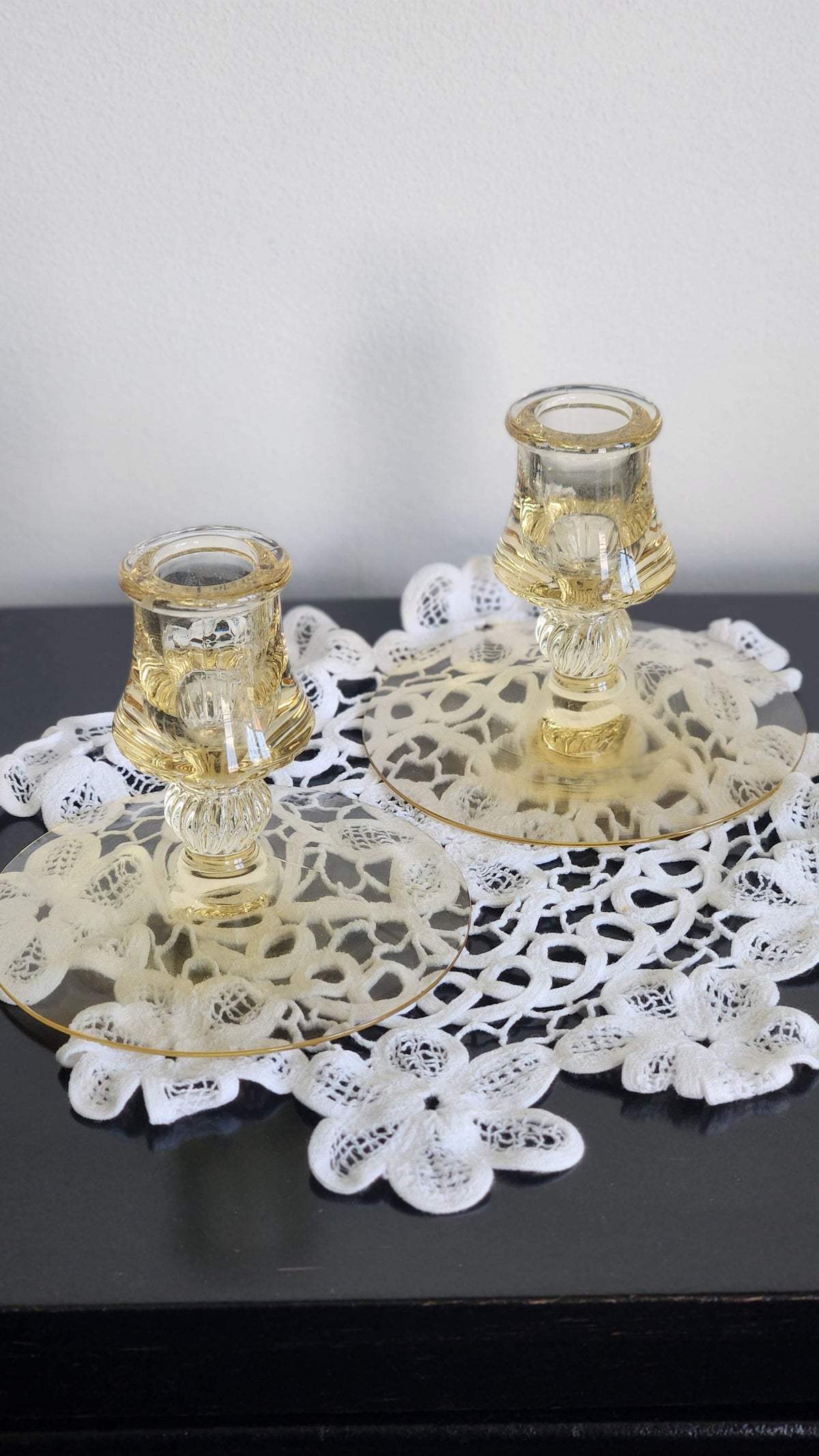 Close view of yellow glass candlesticks showing shaped candle cups and ribbed stems