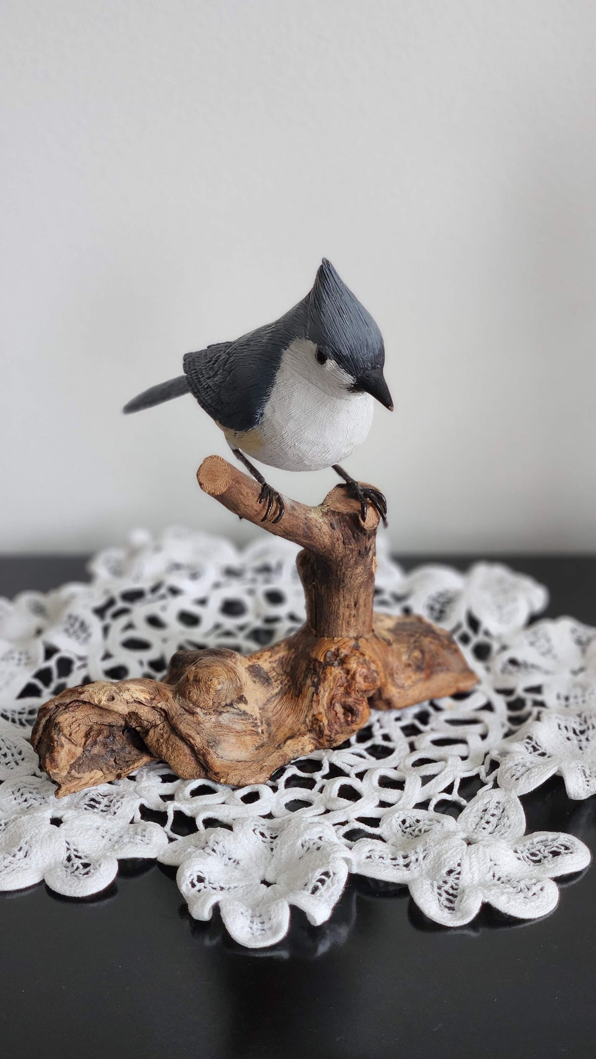 Painted tufted titmouse wood carving on a natural branch perch, front view