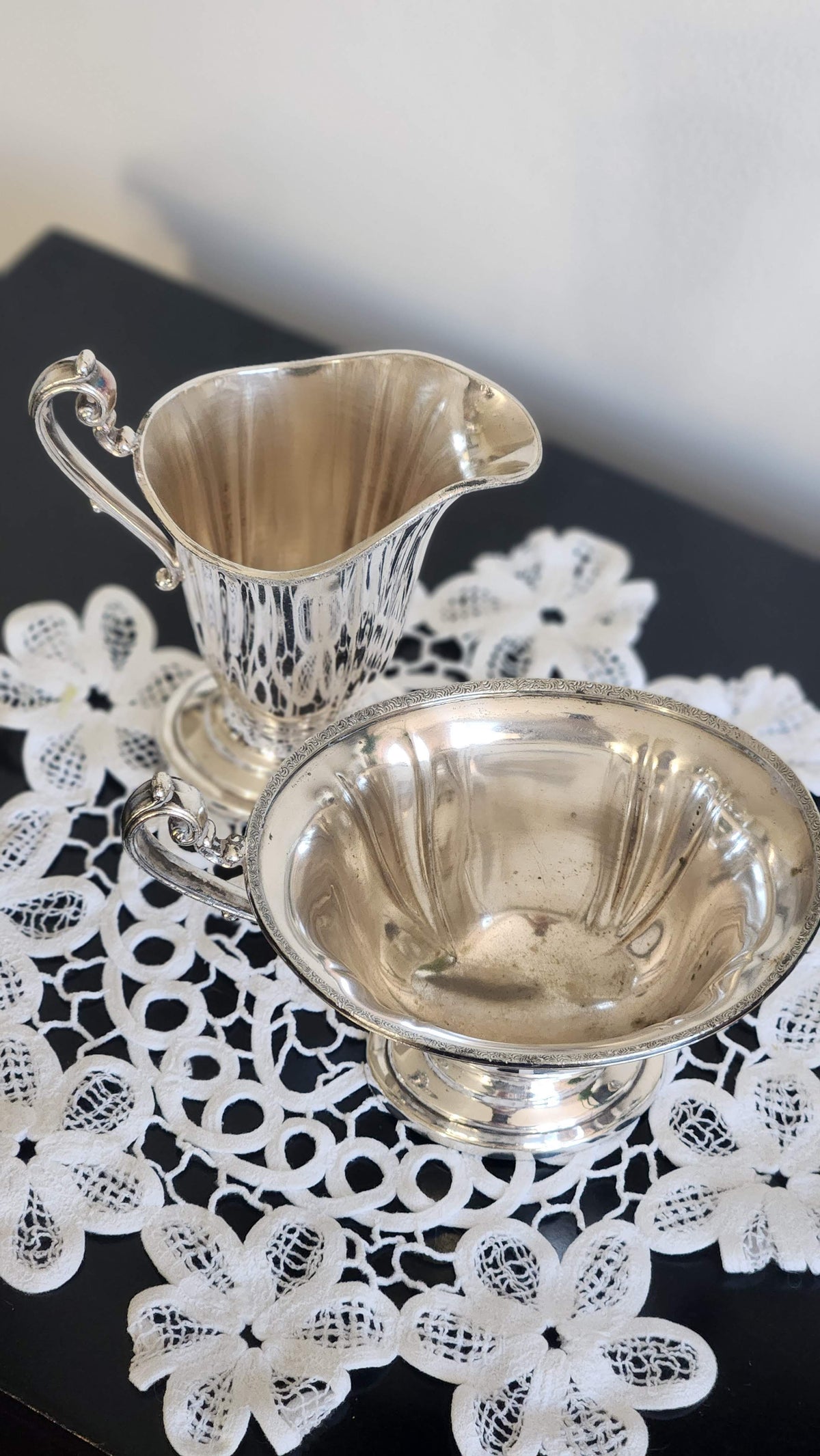 Interior view of silverplate sugar bowl showing mottled wear beside matching creamer